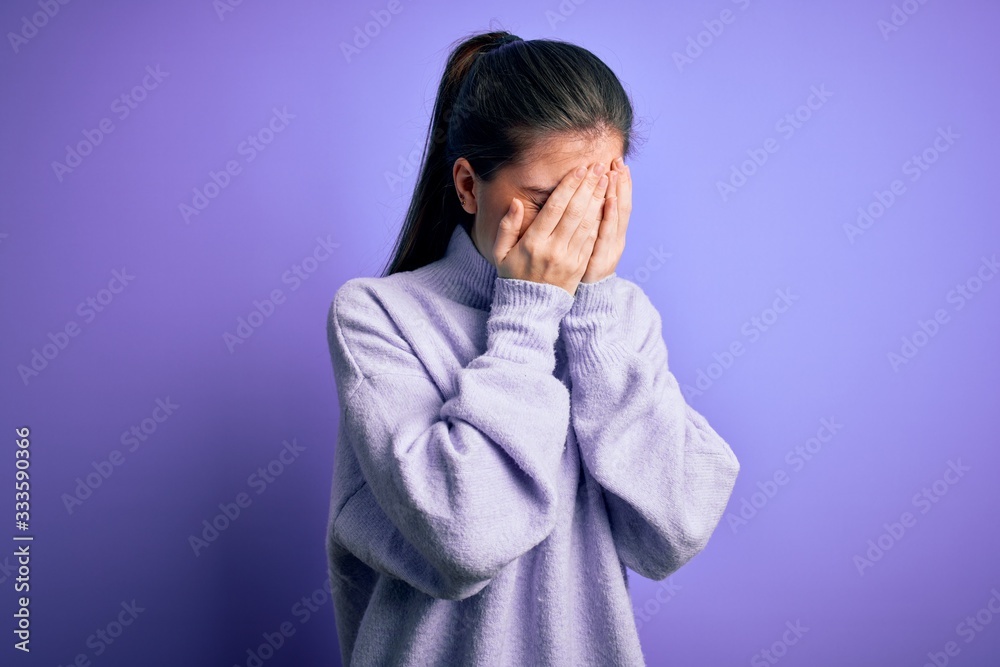 Young beautiful woman with blue eyes wearing casual turtleneck sweater over pink background with sad expression covering face with hands while crying. Depression concept. Young beautiful woman with blue eyes wearing casual turtleneck sweater over pink background with sad expression covering face with hands while crying. Depression concept.