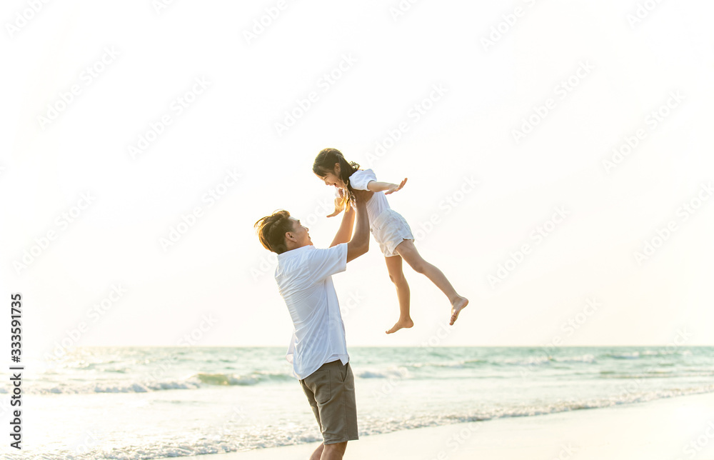 Happy Asian Family father carrying little cute daughter up in the air and looking each other with smiling face on the beach. Dad and child girl having fun in summer lifestyle holiday vacation travel. Happy Asian Family father carrying little cute daughter up in the air and looking each other with smiling face on the beach. Dad and child girl having fun in summer lifestyle holiday vacation travel.