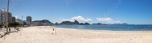 Wide panorama of near empty Copacabana beach and boulevard with the Sugarloaf mountain in the background during the COVID-19 Corona virus outbreak in Rio de Janeiro, Brazil