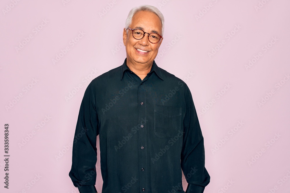 Fototapeta premium Middle age senior grey-haired handsome man wearing glasses and elegant shirt with a happy and cool smile on face. Lucky person.