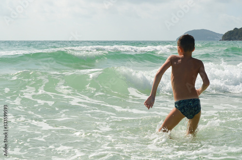 Canvas Print Child caucasian boy rear view dives into the sea