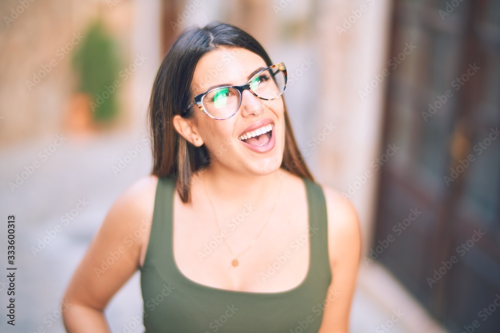 Young beautiful woman smiling happy and confident. Standing with smile on face at the town street Young beautiful woman smiling happy and confident. Standing with smile on face at the town street