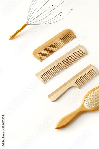 Wooden combs brush and head massage isolated on white background. zero waste accessories. Top view. copy space