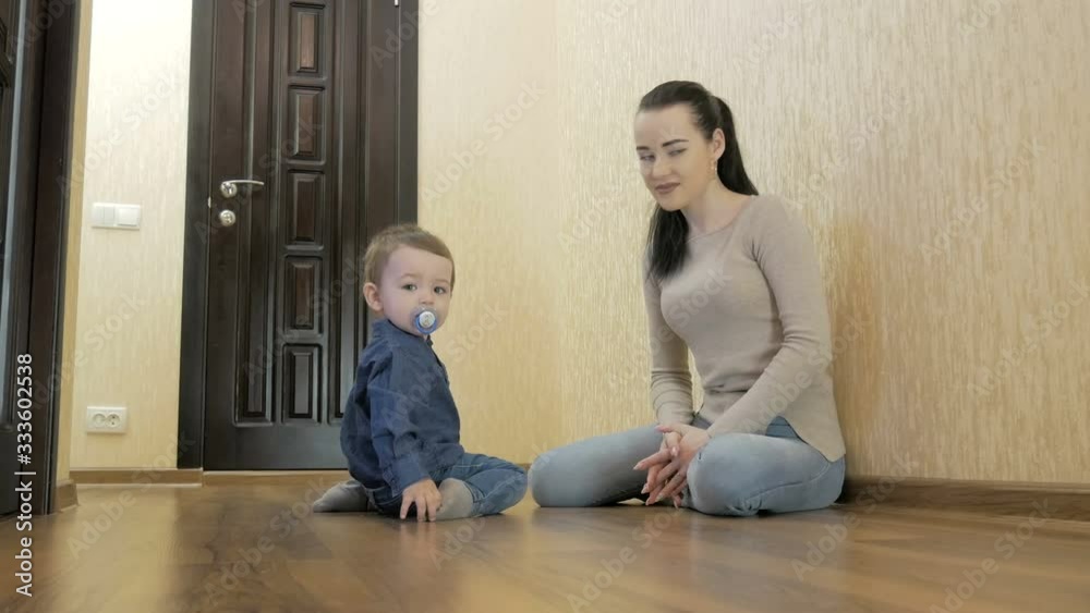 Toddler playing with mom toy cars sitting on the floor Toddler playing with mom toy cars sitting on the floor