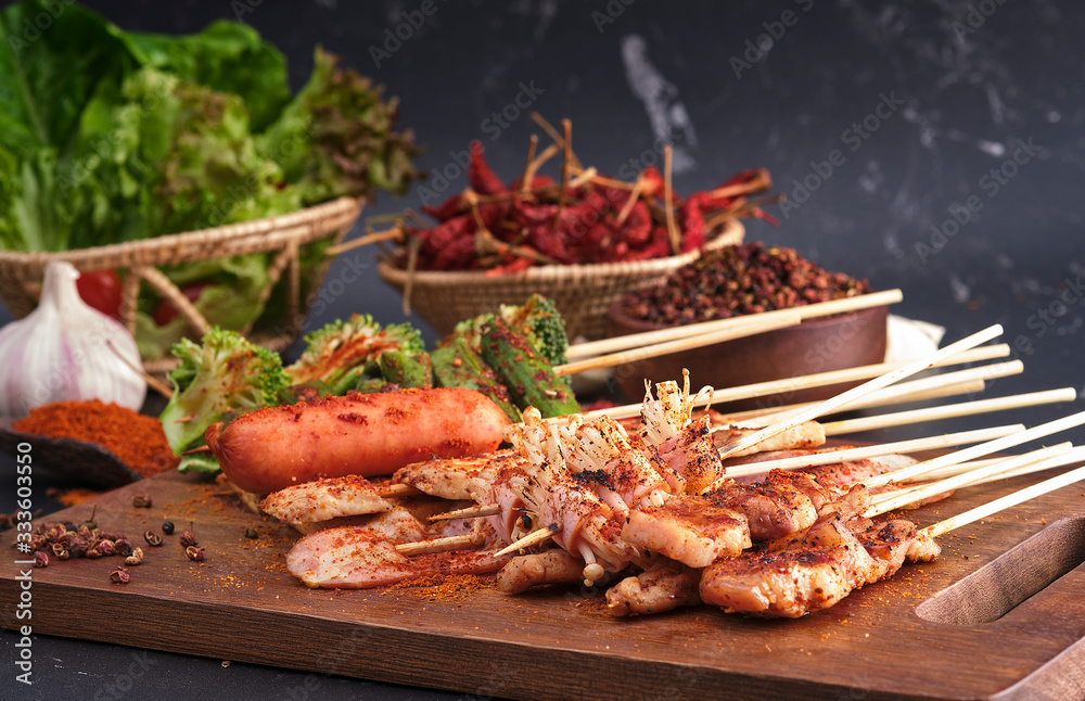 Group of Mala grilled barbecue (BBQ) with Sichuan pepper, Hot and spicy and delicious street food on wood board and ingredients ( Chilli,Sichuan pepper ,Garlic) food on black background. Group of Mala grilled barbecue (BBQ) with Sichuan pepper, Hot and spicy and delicious street food on wood board and ingredients ( Chilli,Sichuan pepper ,Garlic) food on black background.