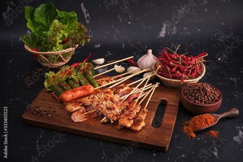 Group of Mala grilled barbecue (BBQ) with Sichuan pepper, Hot and spicy and delicious street food on wood board and ingredients ( Chilli,Sichuan pepper ,Garlic) food on black background.
