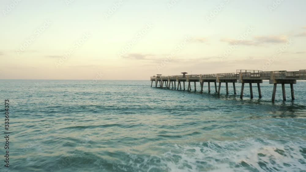 Waves rolling in against the pier at sunset Waves rolling in against the pier at sunset