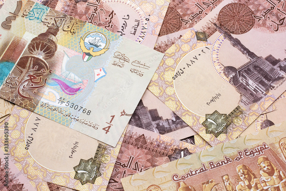 A colorful quarter dinar bank note from Kuwait close up in macro with Egyptian one pound bank notes