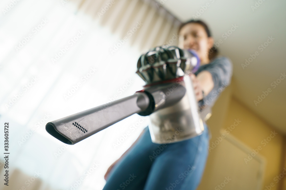 Woman use vacuum cleaner cleaning on floor.