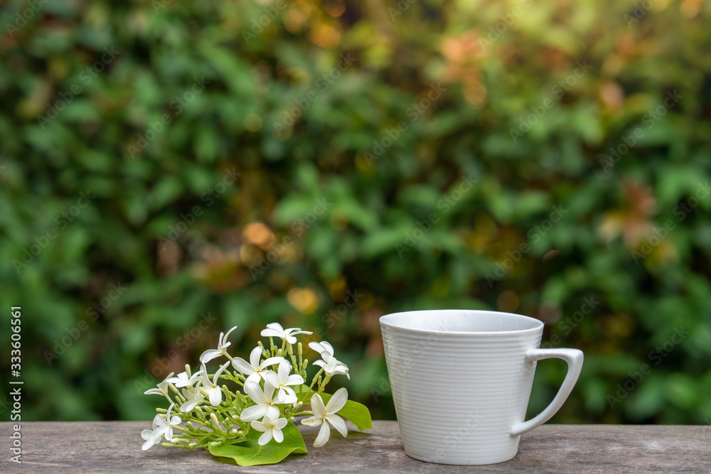 Cup coffee, Holarrhena pubescens flower on wooden table. Cup coffee, Holarrhena pubescens flower on wooden table.