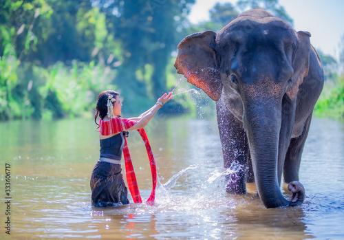 Photography A beautiful woman taking a picture with an elephant in the river.