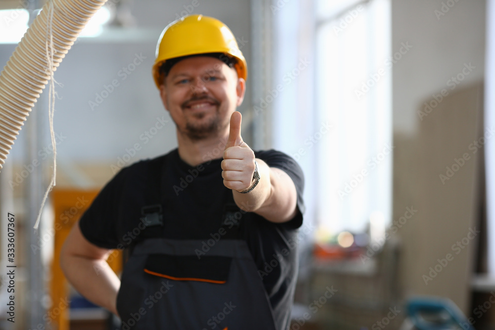Smiling worker in yellow helmet show confirm sign with thumb up at arm portrait. Manual job DIY inspiration joinery startup idea fix shop hard hat industrial education profession career concept Smiling worker in yellow helmet show confirm sign with thumb up at arm portrait. Manual job DIY inspiration joinery startup idea fix shop hard hat industrial education profession career concept