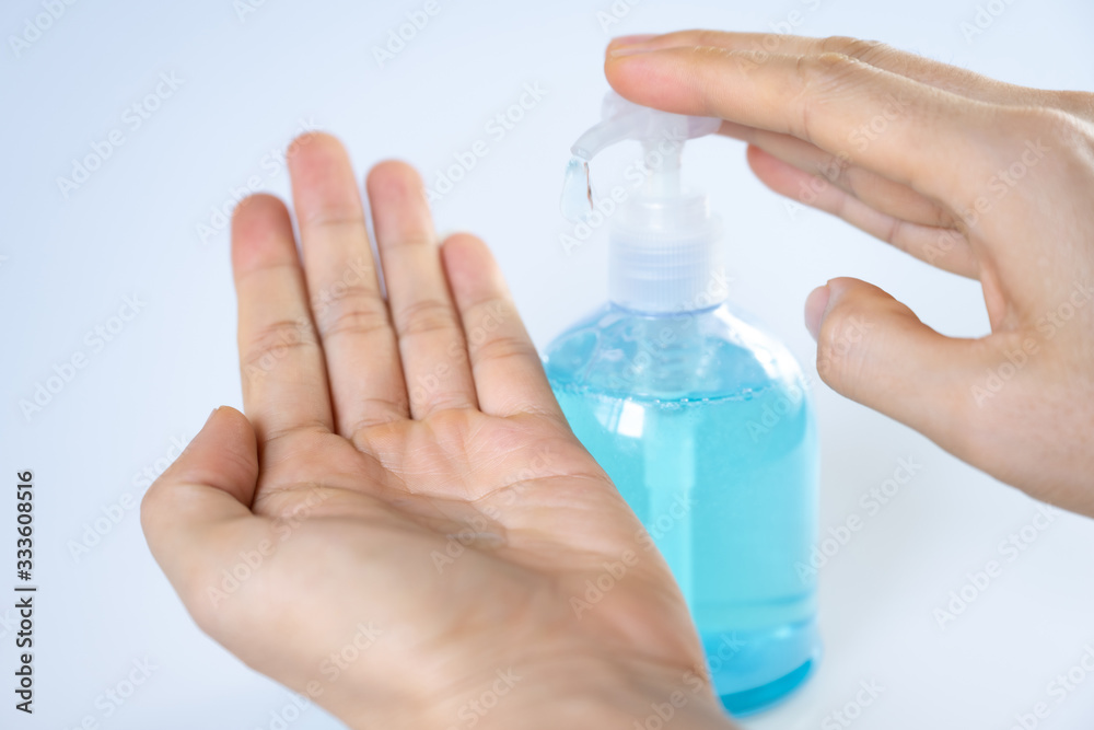 Man washing hands with sanitizer gel bottle or soap for coronavirus prevention, hygiene to stop spreading covid-19 (select focus)