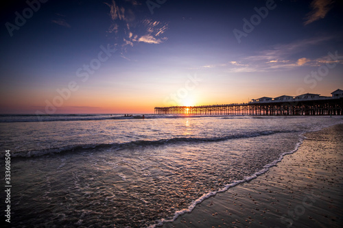 Sunset over the Pier in Pacific Beach, California on a warm cloudy summer evening. photo