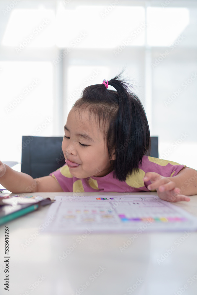 Kindergarten Asian girls doing homework at home with happy face Full of smiles, fun, and enjoyment Kindergarten Asian girls doing homework at home with happy face Full of smiles, fun, and enjoyment