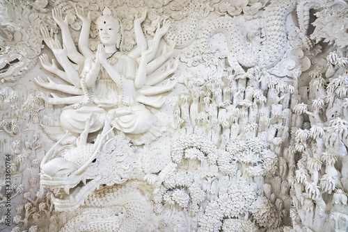 white gaunyim and dragon sculpture on wall of huai pla kang temple in chiang rai