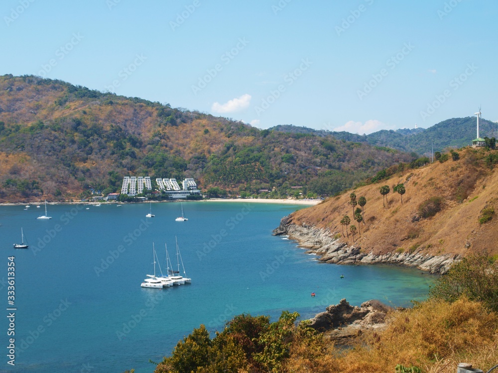 Sea bay with picturesque sandy beaches. Sailing yachts on the surface of the water. The hotel building is on a hillside. A wonderful paradise for a beach holiday.