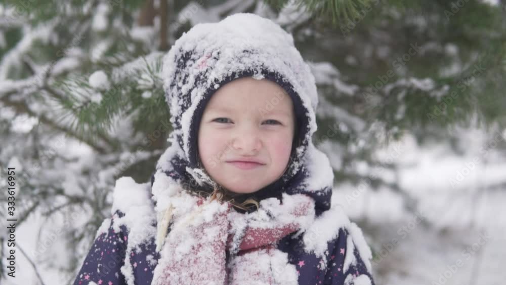A close-up of a little girl in the snow during a winter walk. A close-up of a little girl in the snow during a winter walk.