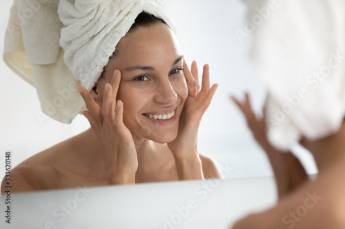 Po zabiegu kosmetycznym w domowym spa kobieta patrzy na idealną skórę w lustrzanym dotyku, twarz czuje się zadowolona. Oczyszczająca maska do twarzy, krem przeciwzmarszczkowy, peeling chemiczny, zabieg przeciwstarzeniowy w koncepcji kliniki