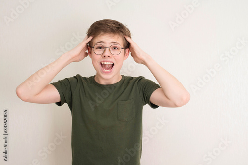 Portrait of surprised teen boy in eyeglasses on white background. Funny boy looking at camera in shock or amazement. Handsome teenager.
