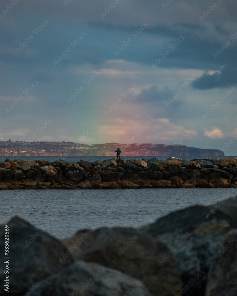 man standing in rainbow