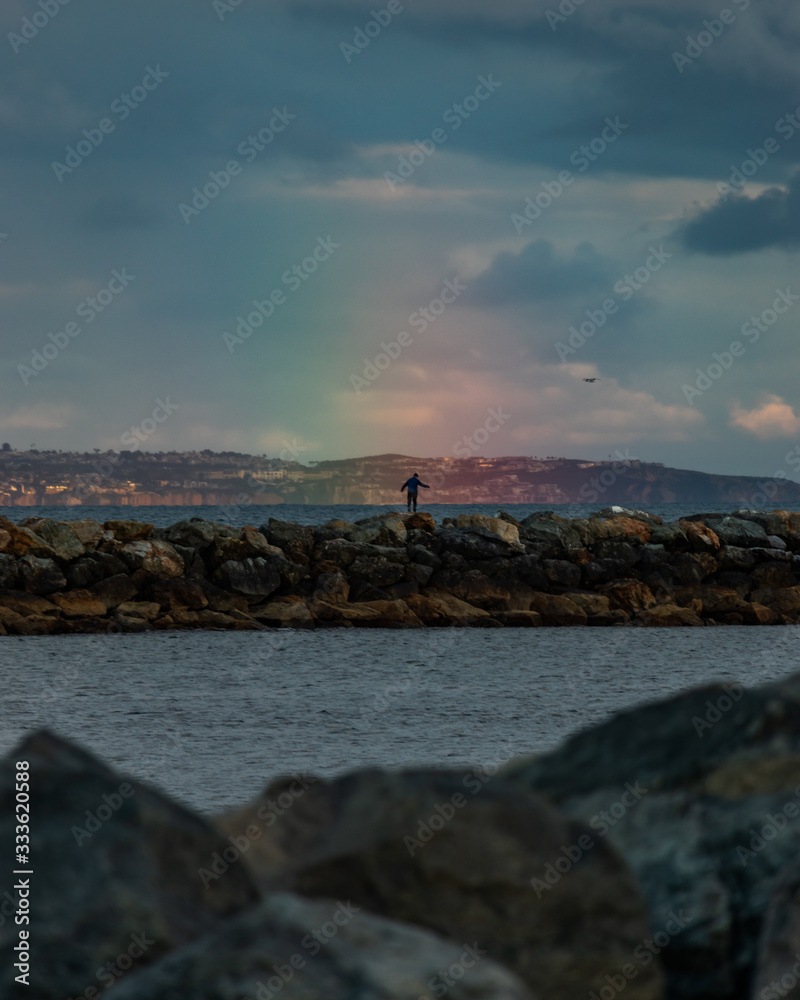 man standing in rainbow