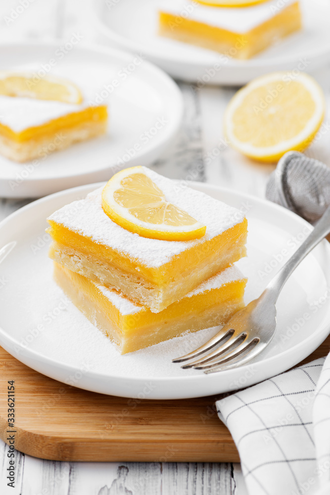 Lemon bar dessert with powdered sugar and lemon slices