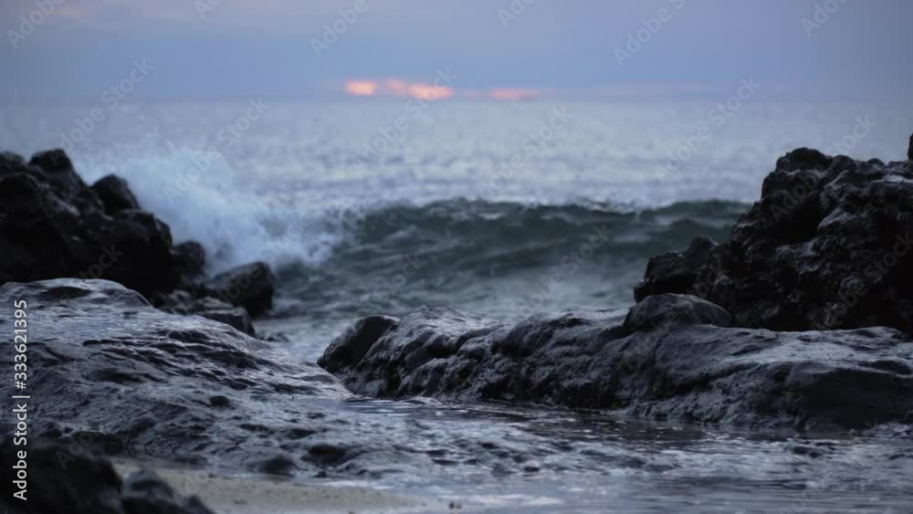 Waves rolling over the rocky shoreline of Fiji during sunset - wide shot Waves rolling over the rocky shoreline of Fiji during sunset - wide shot