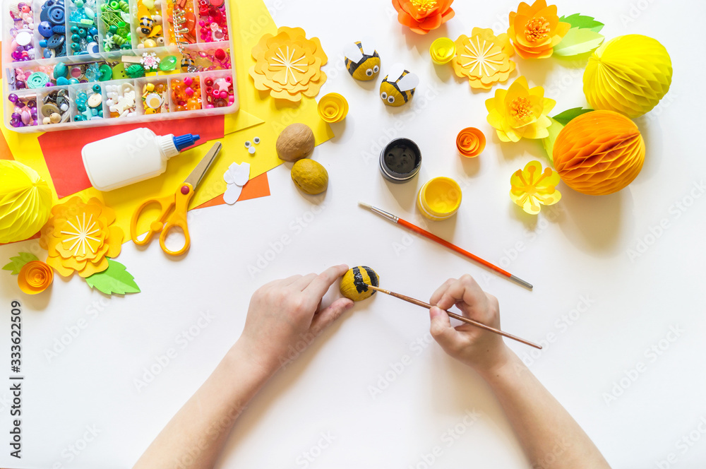 The child makes a bee crafts. Paints and material for creativity. The child makes a bee crafts. Paints and material for creativity.