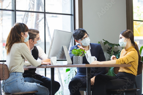Group of business people with wearing hygienic mask prophylactic manager talking in meeting work room planning.