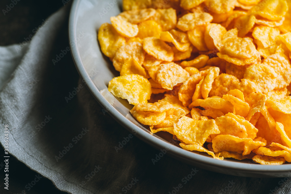 Tasty crispy corn flakes in bowl on the rustic background. Selective focus. Shallow depth of field.