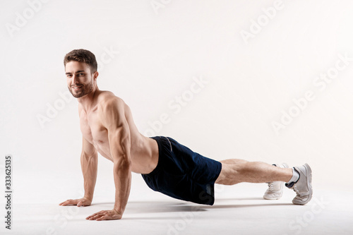 A man on a white background does an exercise on stretching his back. straight loin yoga exercise