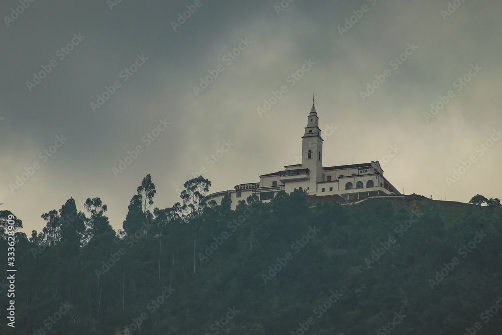 Panoramic view of Montserrat church on top of the hill in Bogota, Colombia on a cloudy hazy day. Mysterious photo of a church above Bogota.
