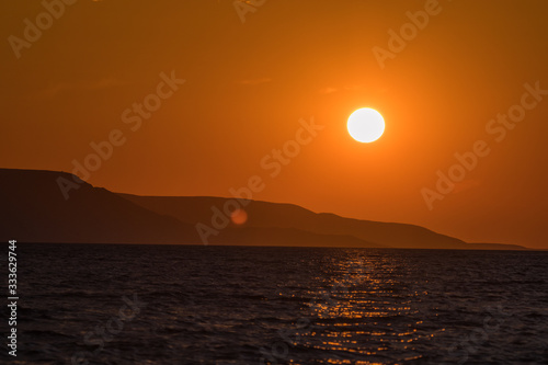 Fototapeta Naklejka Na Ścianę i Meble -  Evening view of croatian coast close to Karlobag with sunset around island of Pag and Rab. Sun just about to set behind clouds to the sea.