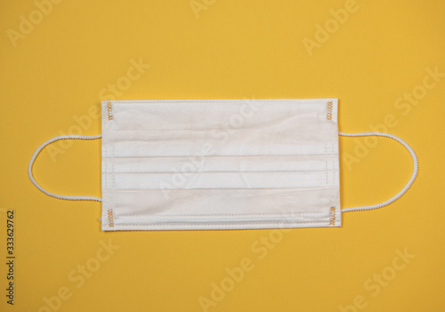 Protective medical equipment during a virus epidemic, Surgical mask on yellow background