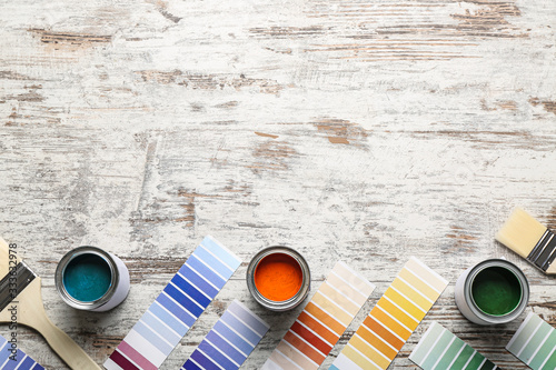 Fototapeta Naklejka Na Ścianę i Meble -  Color swatches with paints and brushes on wooden table
