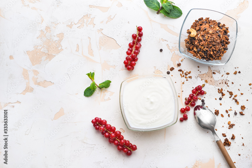 Bowls with tasty yogurt, granola and berries on white background