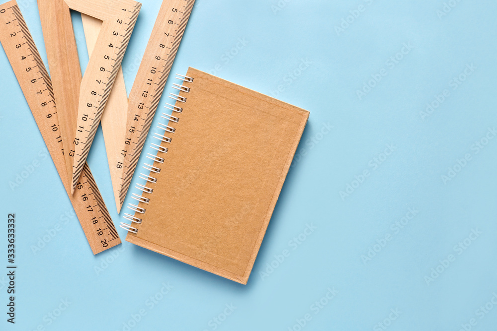 Notebook with rulers on color background Notebook with rulers on color background
