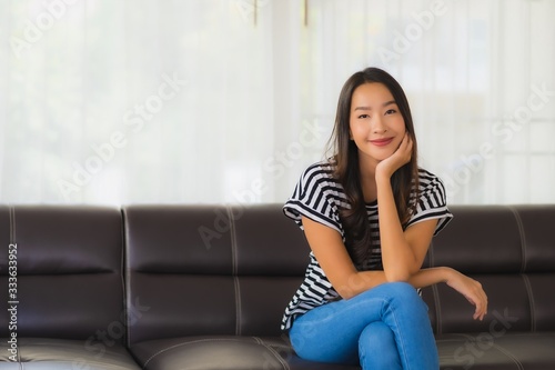Free Download Portrait beautiful young asian woman happy smile relax on sofa in living room - GFXLoad