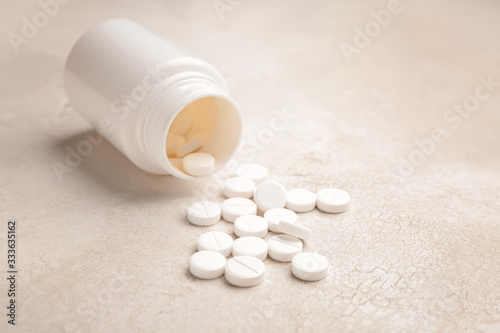 Jar with pills on light background