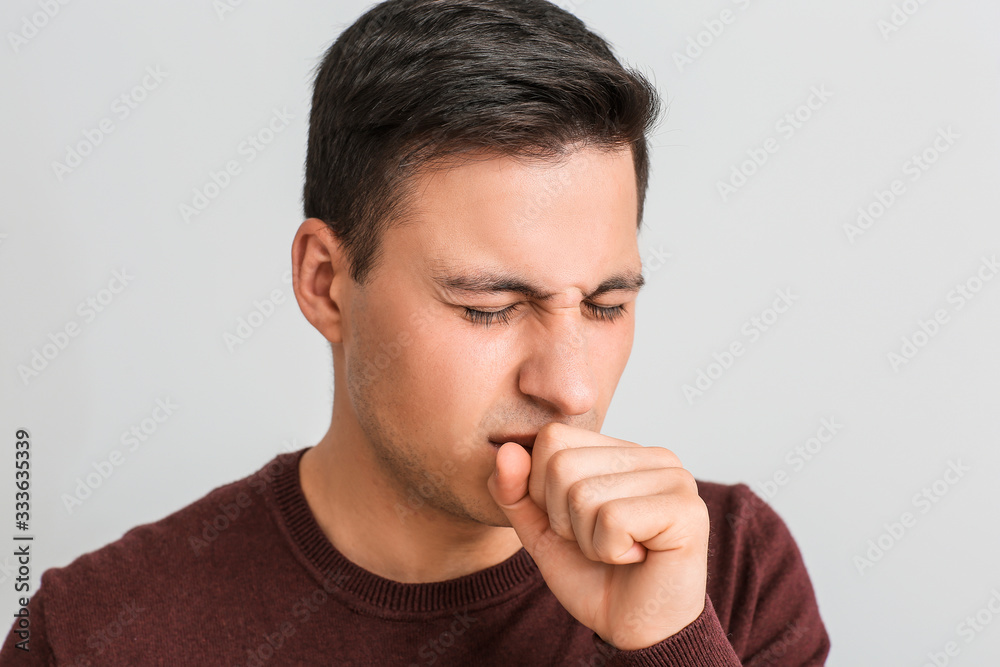 Coughing young man on light background Coughing young man on light background