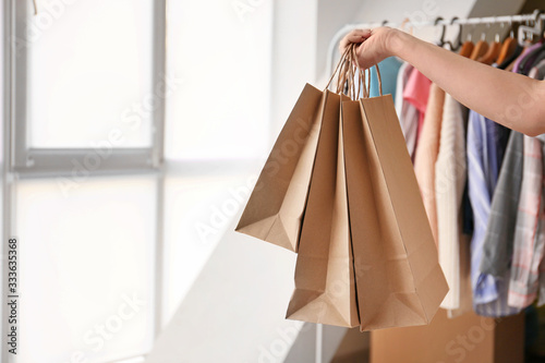 Woman with paper shopping bags at home