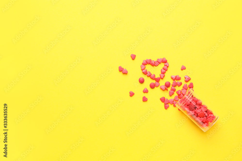 Jar and heart made of pills on color background