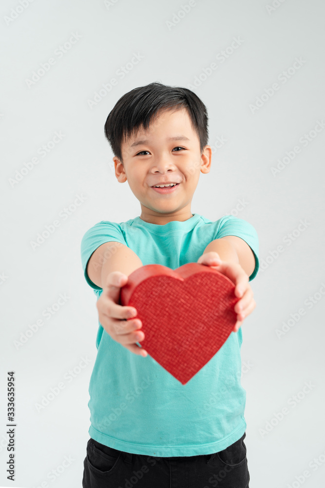 Happy boy in love holding heart shaped gift box Happy boy in love holding heart shaped gift box
