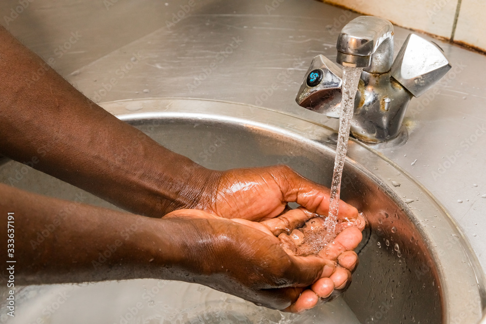 African person washing hands in basin to protect against spread of virus - obrazy, fototapety, plakaty 