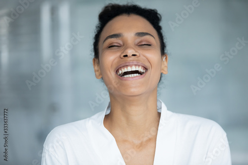 Canvas Print Head shot african cheerful woman in white bathrobe laughing in bathroom