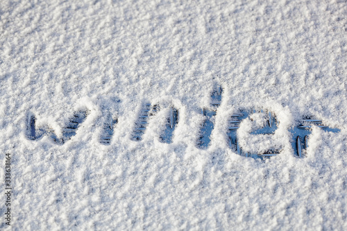a word 'winter' written on the snow surface © Ekaterina Shvaygert