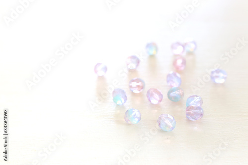 Pink and blue multicolored beautiful crystal drops beads over white wooden background