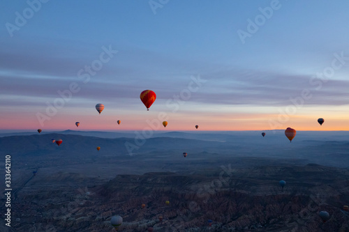 balloons seen from Goreme, Cappadocia with beautiful sunrise and colourful, golden, orange, pink and blue sky. It's fun, excited and impress activity at Turkey.