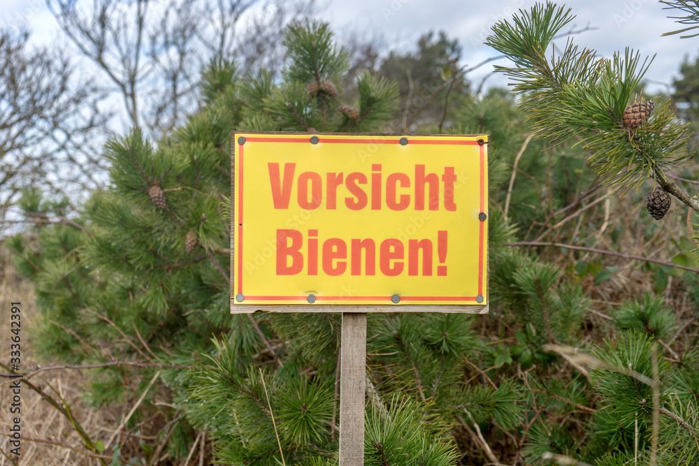 Warning sign in nature with German text: Beware of bees